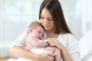 Frau misst Fieber bei ihrem Baby