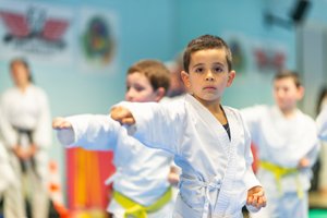 kleiner Junge trainiert Karate mit Freunden