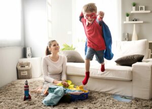 Kind springt im Superhelden-Outfit von der Couch