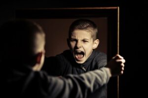 aggressives Kind schreit sein Spiegelbild an