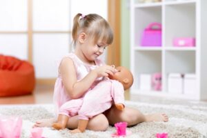 kleines Mädchen umsorgt seine Puppe