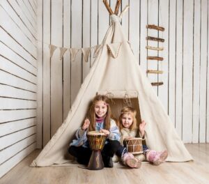 zwei Kinder spielen Indianer in einem Zelt