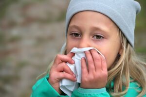 erkältetes Mädchen putzt sich die Nase