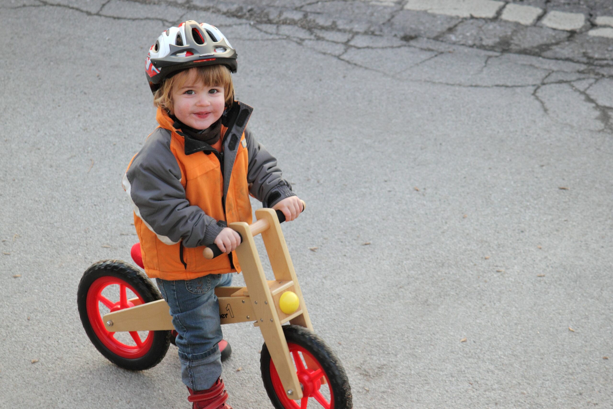 Kind trägt zur Sicherheit Helm auf Laufrad