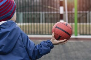 ein kind haelt einen handball in der hand