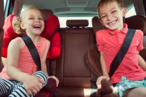 Kinder sitzen auf Sitzerhöhungen im Auto