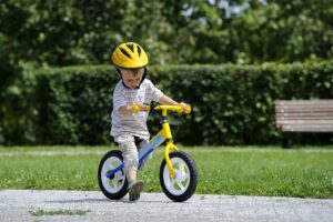 Junge fährt auf einem Laufrad mit Stange