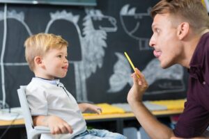 Lehrer übt Sprache mit Kind