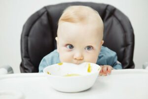 ein baby isst suppe