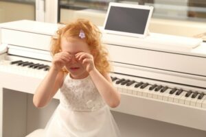Mädchen weint am Klavier