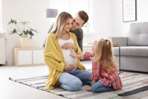 junge schwangere frau mit ihrem mann und ihrem kind zuhause